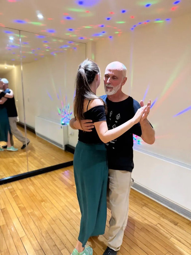 Partners dancing under colourful party lights