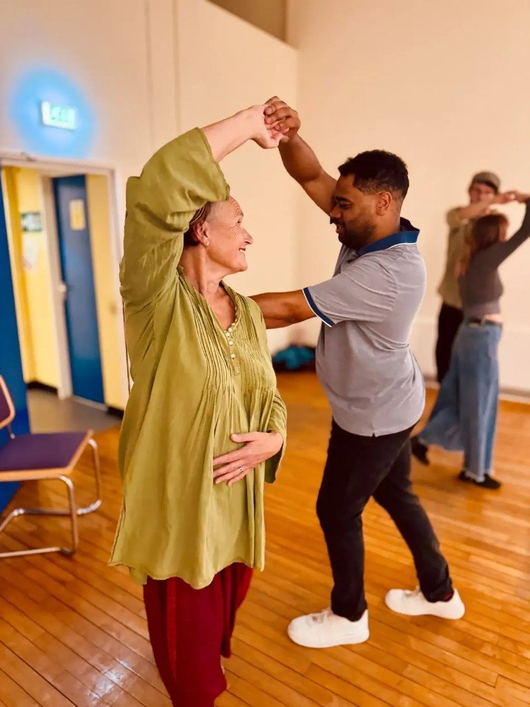 Smiling dancers turning together on the studio floor